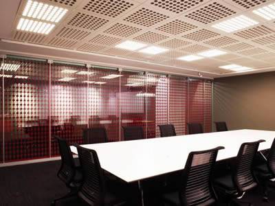 Perforated copper metal sound barrier is installed in the ceilings of offices.