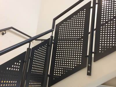There are several black perforated metal infill railings.
