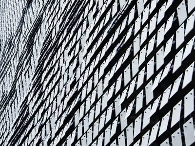 Many perforated kinetic plates are covering a building.