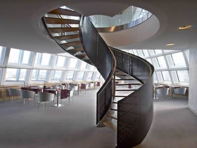 There is a spiral stair with black perforated metal railings supporting this leisure place.