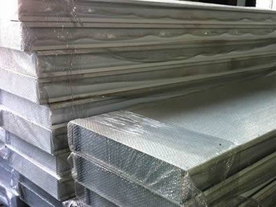 Perforated metal sound barrier sheets are packaged by wooden boards and tapes.