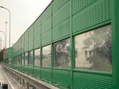 Combination of perforated metal and PC sound barrier in between residential area and urban road.