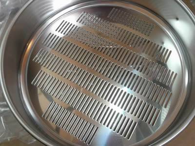 The picture shows a perforated test sieve with slotted holes.