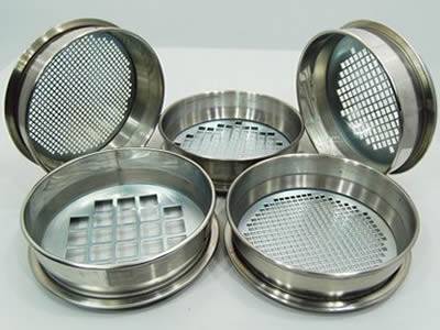 Five perforated test sieves with square holes have different sizes.