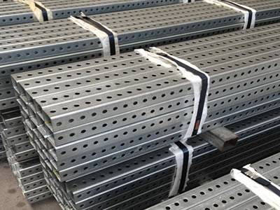Steel square perforated pipes for road sign posts packaged in warehouse.