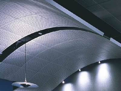 There is a droplight hanging on the suspended perforated metal ceiling.